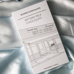 Block of artisan milk chocolate from Schoko Chocolates in white packaging with a black line drawing.