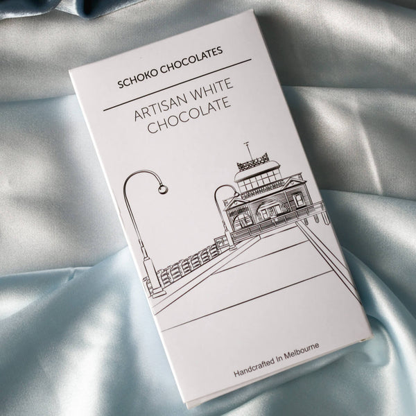 Block of artisan white chocolate from Schoko Chocolates in white packaging with a black line drawing.